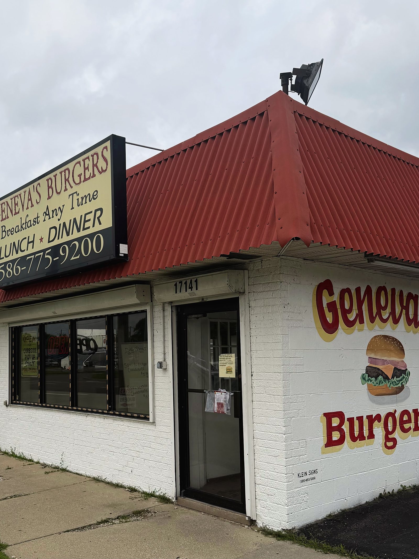 The front of Geneva's Burgers on 8 Mile Road, red roof and a sign reading breakfast any time.